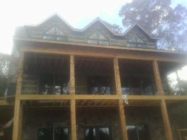 Dormers and porch framing on a large log home under construction — Roof Coating work by our crew in West Terre Haute