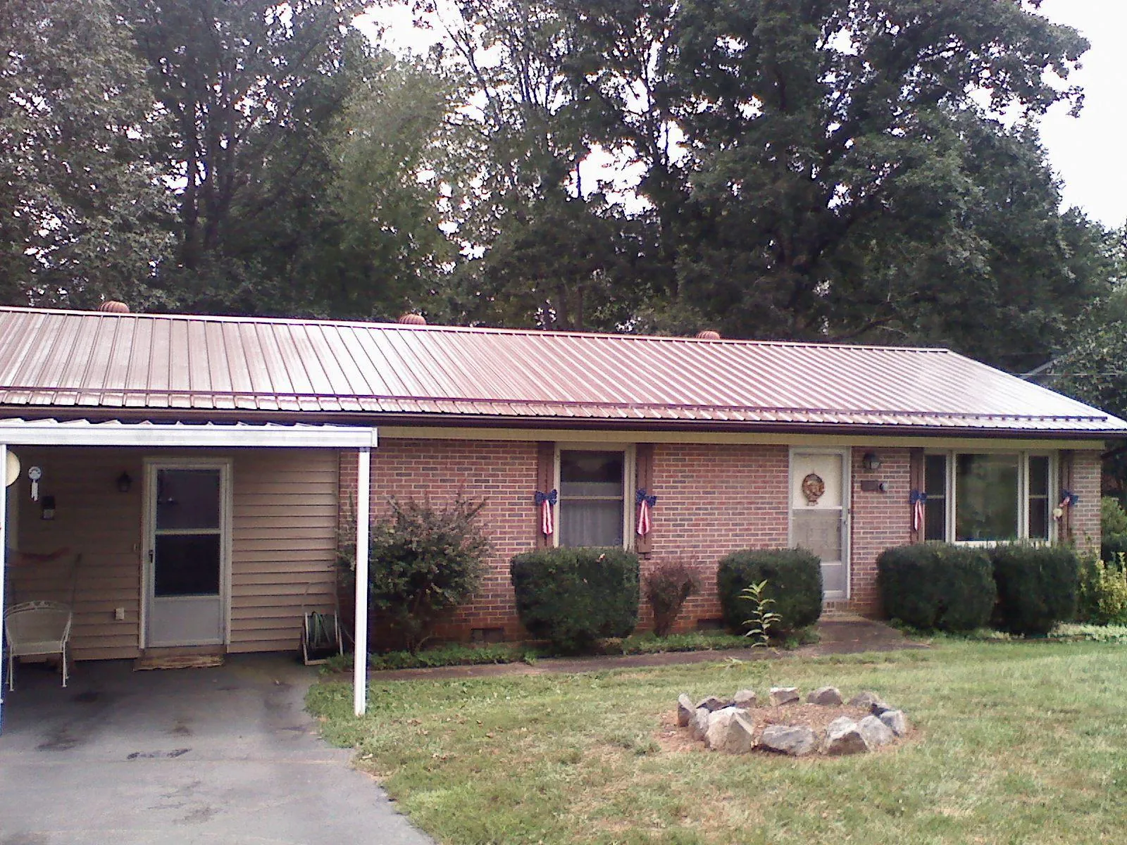Bronze metal roof and carport on a brick ranch home — Roof Repair work by our crew in West Terre Haute